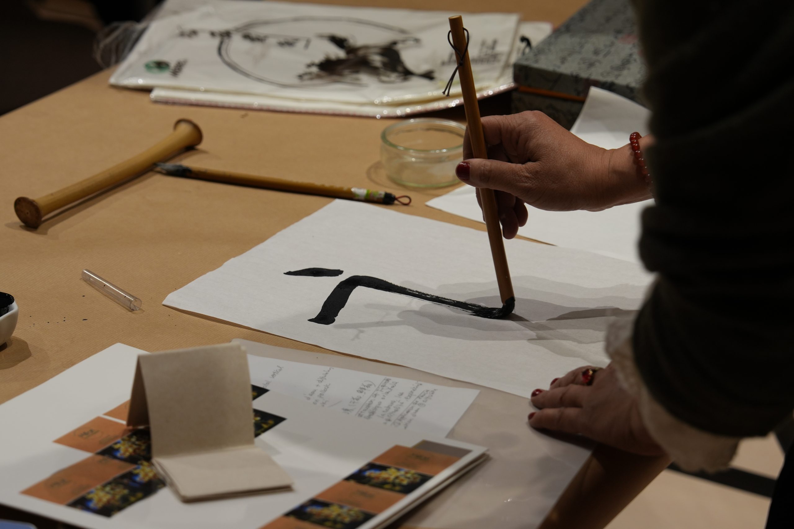 Une caligraphe déssine une lettre de façon traditionnel