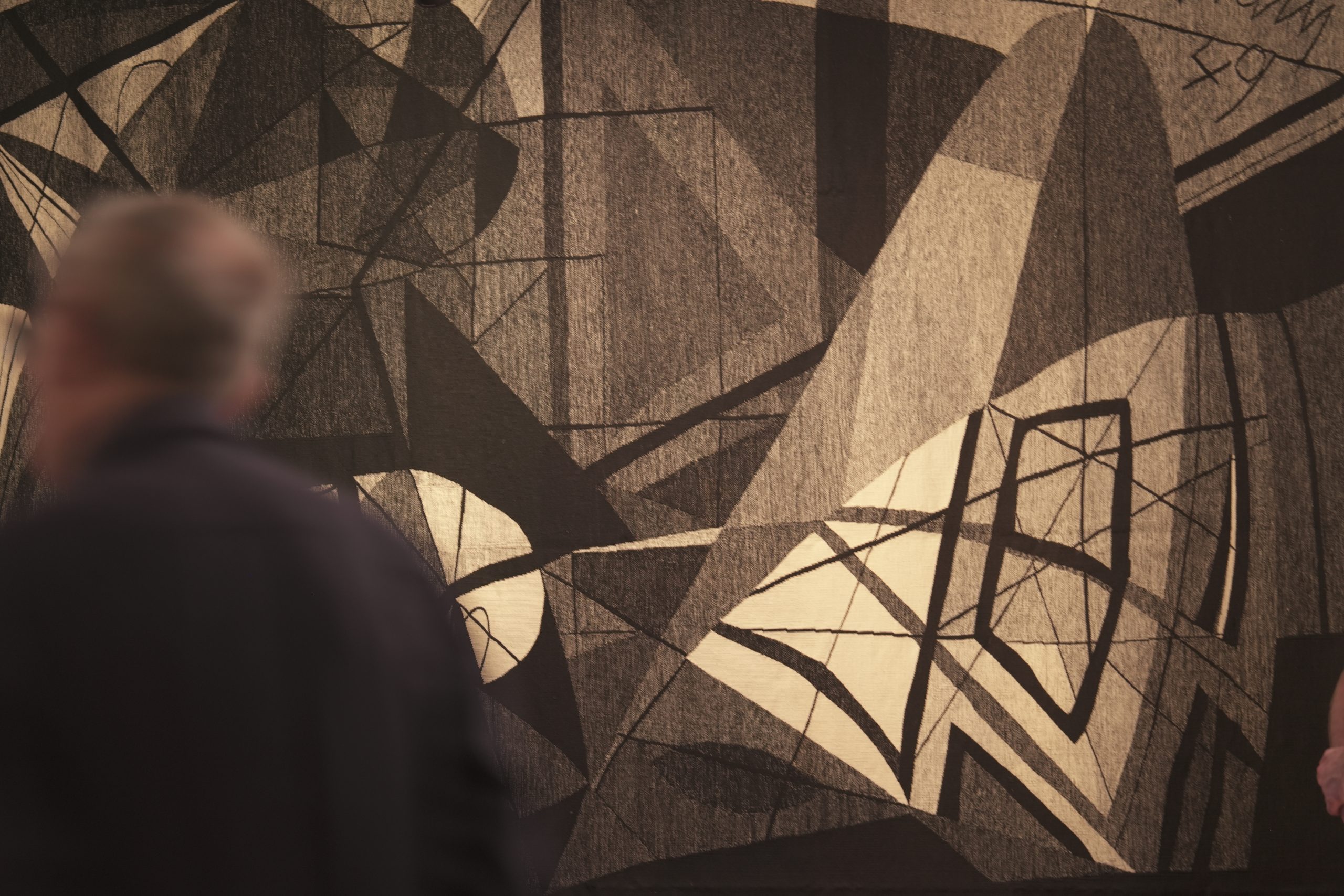 Photo de l'exposition Henri-Georges Adam une tapisserie et une silhouette de dos.