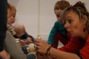 Une médiatrice montre a des jeunes enfants un objet de façon surprenante